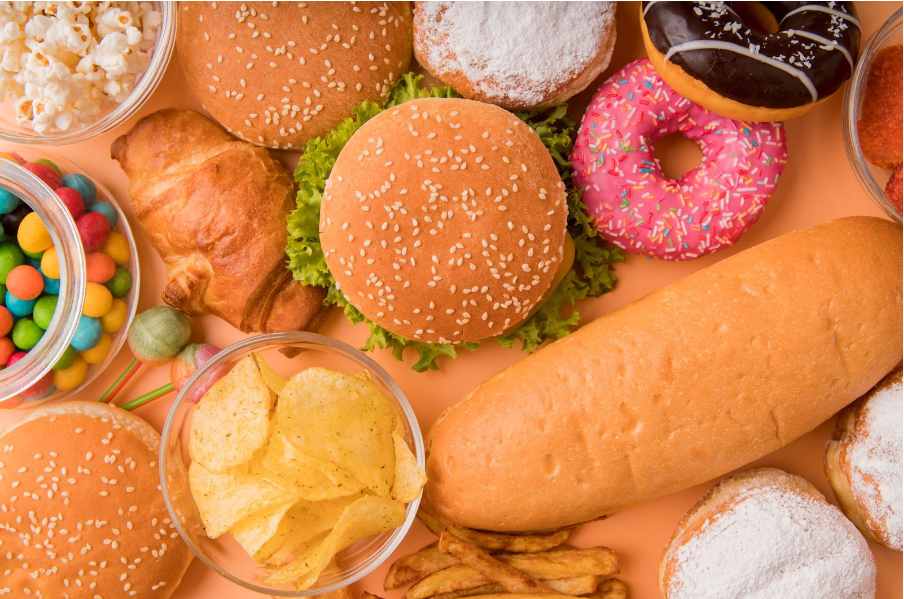 Imagem mostra diversos alimentos ultraprocessados como hamburguer, rosquinhas, etc